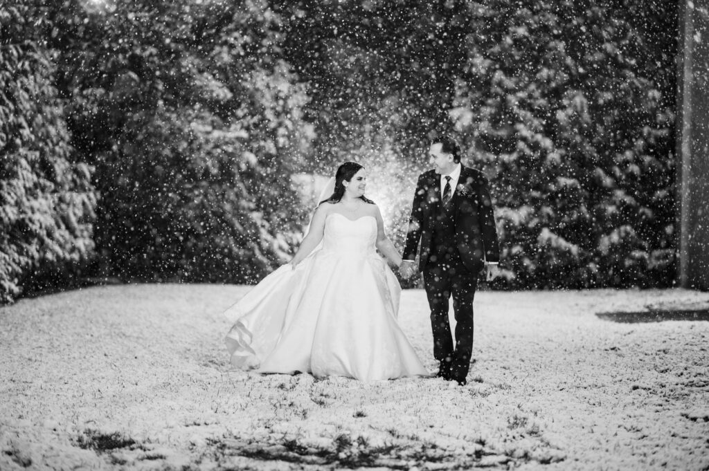 romantic portrait of couple walking in snow at Pen Ryn Mansion