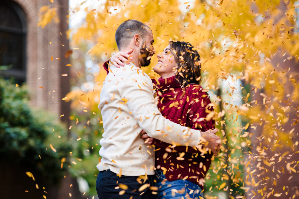 couple embracing with yellow leaves falling around them in Philadelphia