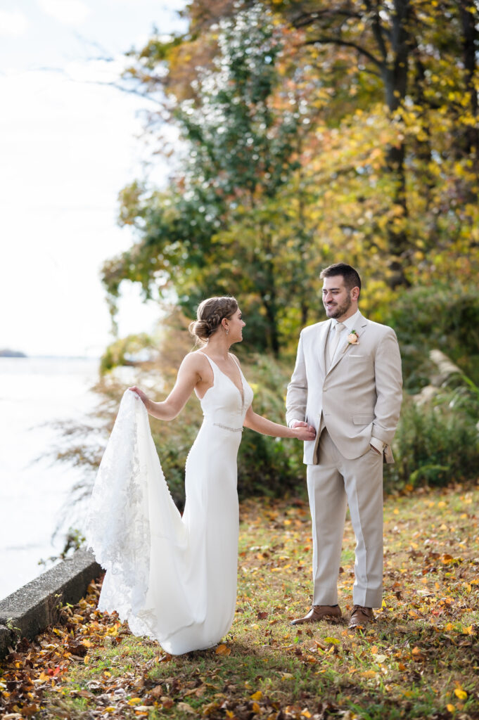 bride and groom standing at delaware river at pen ryn estate
