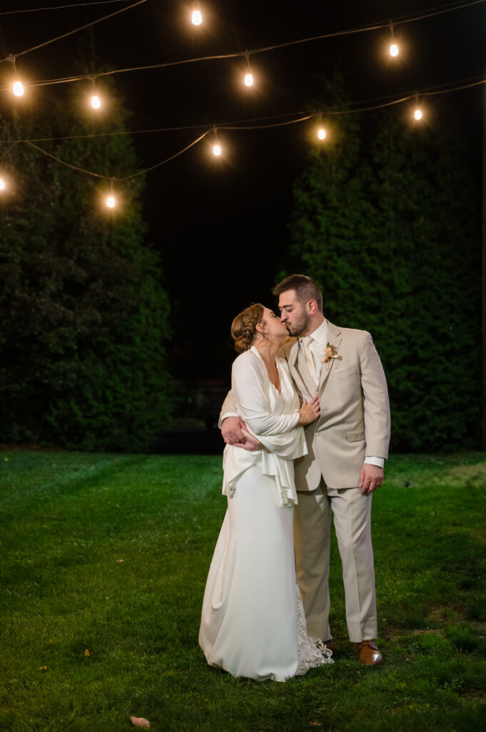 bride and groom kissing under lights at pen ryn mansion