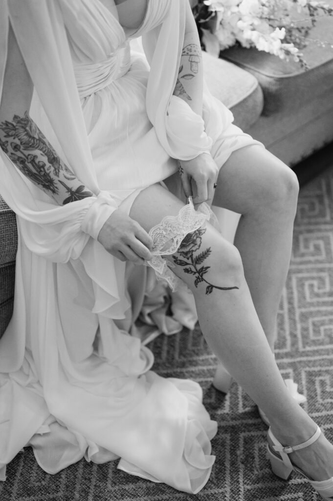 bride pulling up her garter and showing tattoo at woolverton inn