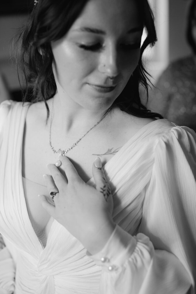 bride touching her necklace during bride prep at woolverton inn