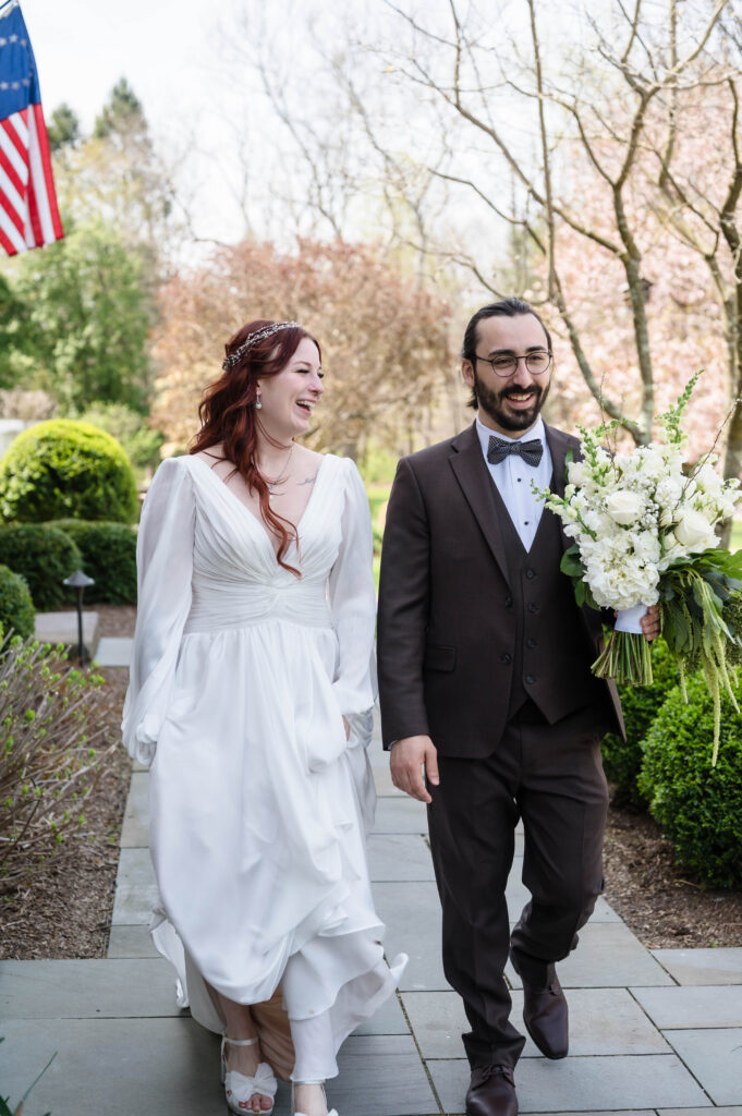 candid moment of bride laughing while walking with groom at woolverton inn