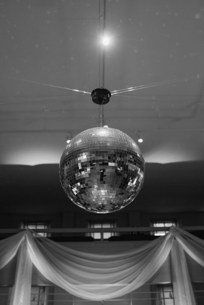 disco ball hanging over wedding reception dance floor